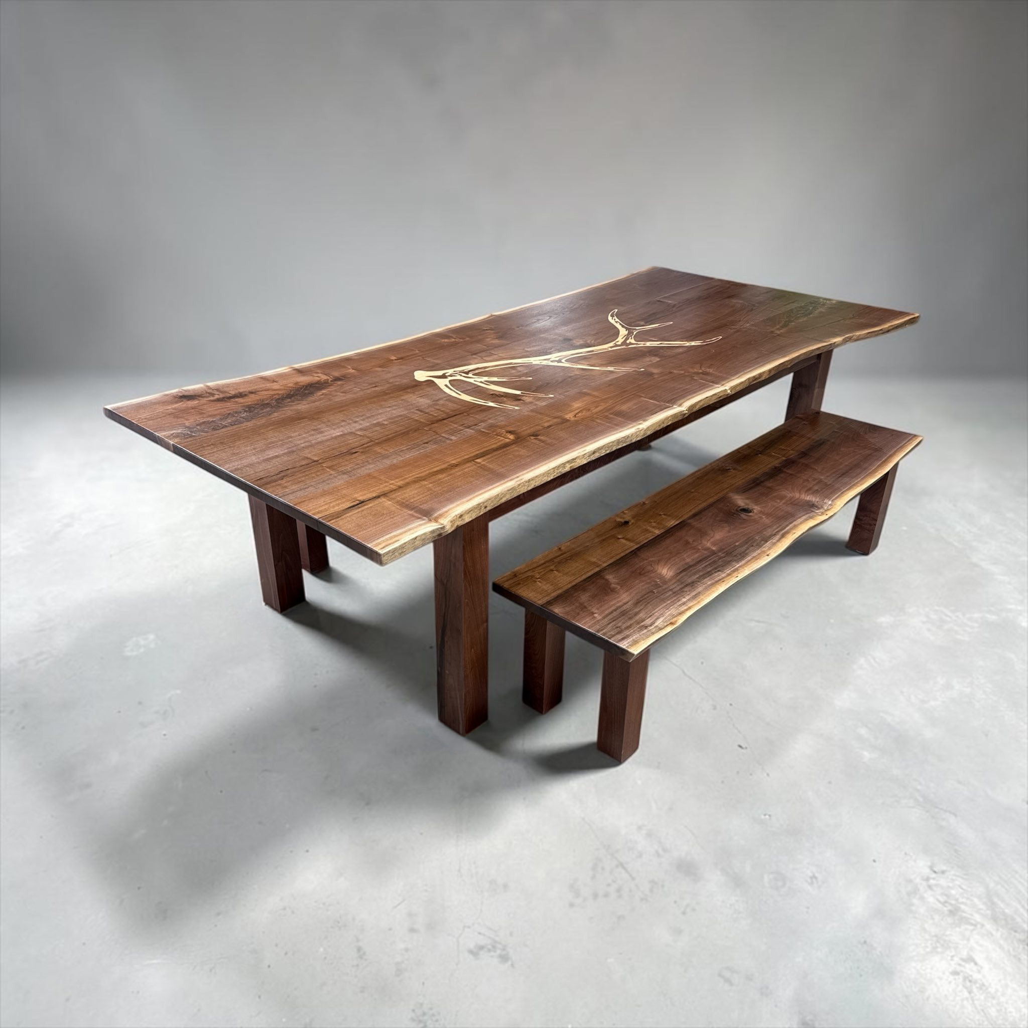 Live-edge walnut dining table with hand-cut antler inlay